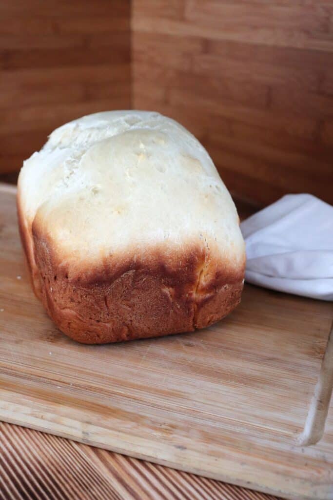 A loaf of Hawaiian bread sits on a board with a white napkin next to it.