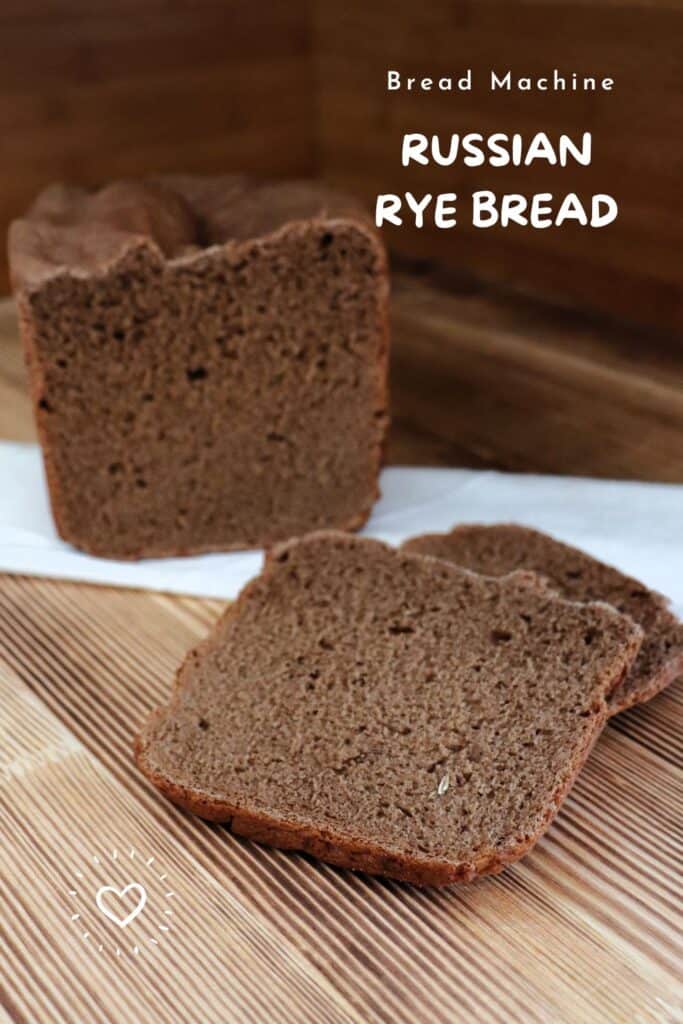 Slices of dark rye bread sit on a board with the remaining loaf sitting ona white cloth behind them. Text overlay reads: Bread Machine Russian Rye Bread