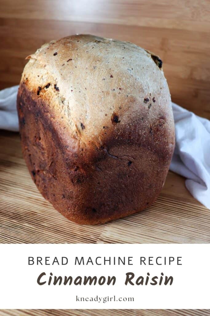 A loaf of bread sits on a table with a cloth behind it. Text overlay reads: Bread Machine Recipe Cinnamon Raisin.