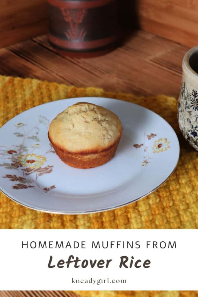A muffin sits on a plate decorated with flowers. A clay pot in the background. Text overlay reads: Homemade Muffins From Leftover Rice.